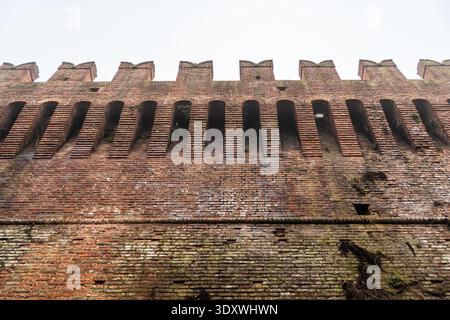 Tiro ad angolo basso delle imponenti mura difensive del Castello Sforzesco di Soncino, Italia. L'immagine evidenzia le macchicolazioni (cornici) e la chara Foto Stock