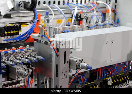 Sistema pneumatico di macchine industriali per la produzione automatizzata. Elettrovalvole, attuatori, cilindri pneumatici, tubi flessibili, raccordi e altri componenti pneumatici Foto Stock