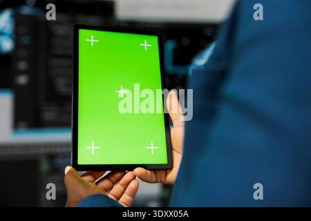 Ingegnere afroamericano mostra tablet con display isolato con finestra terminale in background, trasformazione digitale. Presentazione dello sviluppo software con la scienza dei dati. Primo piano. Foto Stock