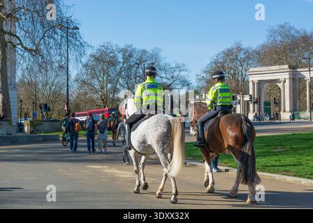 Polizia a cavallo su Apsley Way, il percorso cerimoniale, con lo schermo di Hyde Park sullo sfondo, Hyde Park Corner, Londra, Inghilterra Foto Stock