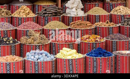 Vivace esposizione di varie spezie tradizionali, erbe essiccate e minerali naturali in ciotole decorative ricoperte di tessuto in un mercato orientale. Foto Stock