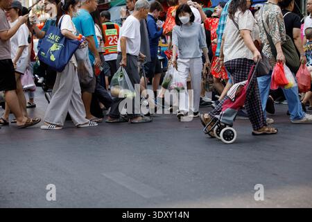 BANGKOK, THAILANDIA - 7 febbraio 2026: Folla che passa l'un l'altro, pedoni che si dirigono in direzioni diverse, movimento a piedi, vista frontale Foto Stock