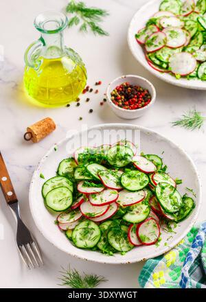 Insalata vegetariana di verdure fresche, ravanelli, cetrioli, aneto, prezzemolo e cipolle verdi con olio d'oliva e spezie. Antipasto vitaminico. Dieta, disintossicazione. Lui Foto Stock