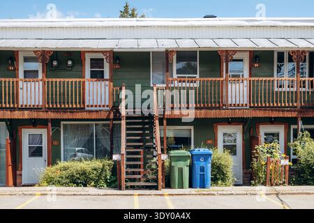 Baie-Saint-Paul, Canada - 22 agosto 2025: Edificio residenziale con scalinata esterna in legno, corridoio con balcone e ingressi degli appartamenti a Baie Saint Foto Stock