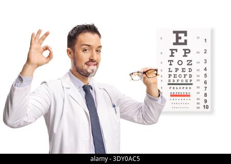 Medico oculista che tiene un paio di occhiali davanti a un test della vista oculare isolato su sfondo bianco Foto Stock