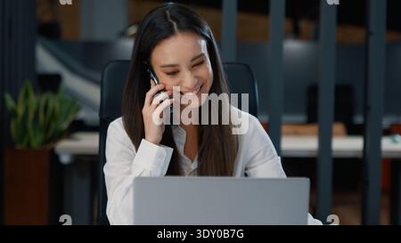 Nervosa emotivamente donna d'affari caucasica che parla telefono digita un laptop donna d'affari che urla alla chiamata mobile parlare ad alto volume lavoro al computer online Foto Stock
