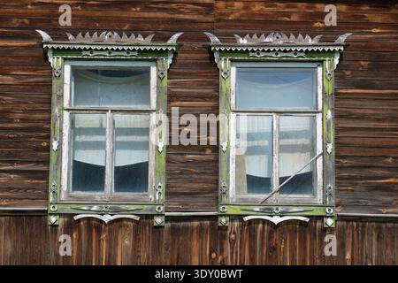 Due finestre di una vecchia casa di legno. Sysert, Ural. Russia Foto Stock