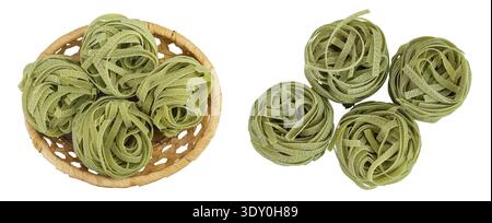 Tagliatelle crude di pasta verde con spinaci in un cestino di vimini isolato su fondo bianco. Vista dall'alto. Spianatura piatta. Foto Stock