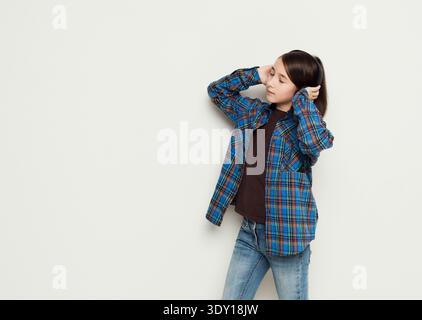 Ragazza ascolta la musica con gli auricolari, riprese in studio Foto Stock