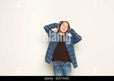 Ragazza ascolta la musica con gli auricolari, riprese in studio Foto Stock