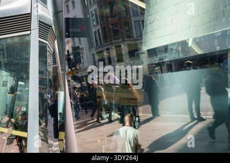 Pedoni e passanti camminano attraverso un paesaggio urbano di luci, ombre e riflessi di vetro su Cannon Street nella City di Londra, il quartiere finanziario della capitale, il 5 marzo 2026, a Londra, Inghilterra. Foto Stock
