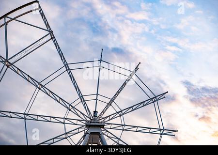 Struttura della ruota panoramica contro un cielo colorato al tramonto, costruzione di un parco divertimenti Foto Stock