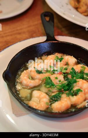 Gamberi all'aglio (Gambas al Ajillo) serviti in una padella come piatto di tapa in un ristorante locale. Siviglia, Spagna Foto Stock