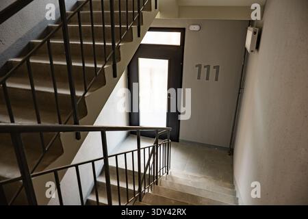 Scala in un edificio moderno con il numero 111 accanto ad una porta Foto Stock