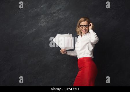 Donna d'affari con documenti su sfondo grigio Foto Stock