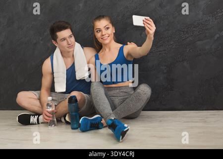 Giovane coppia che fa selfie in palestra Foto Stock