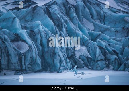 Primo piano dell'antico ghiaccio blu con strisce di cenere vulcanica sul ghiacciaio Svínafellsjökull, il luogo cinematografico delle riprese di "Interstellar" Foto Stock