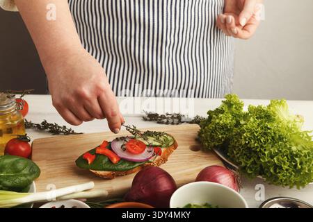 Donna che prepara gustose bruschette per uno spuntino sano, primo piano Foto Stock