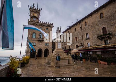 Il Palazzo pubblico e la Statua della Libertà in Piazza della Libertà nella Repubblica di San Marino con le bandiere che soffiano Foto Stock