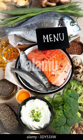 Composizione con prodotti ricchi di vitamina D su sfondo bianco, vista dall'alto. Fonti naturali di vitamina D (pesce, formaggio, uova, funghi). Foto Stock