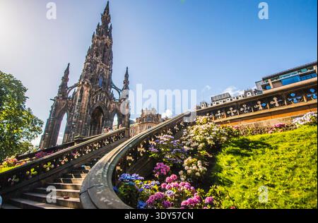 Fiori colorati e una scala vittoriana incorniciano il Gothic Scott Monument nei Princes Street Gardens, Edimburgo. Un omaggio a Sir Walter Scott. Foto Stock