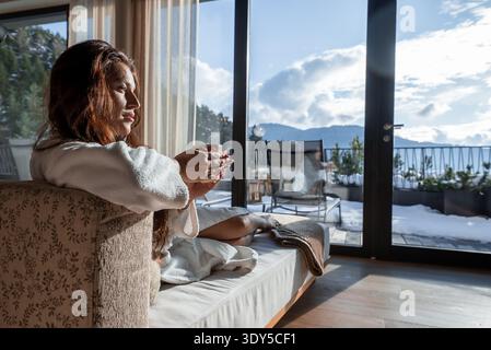 Gli ospiti nella vasca idromassaggio si rilassano su porte di vetro con vista sulle Dolomiti Foto Stock