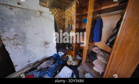 Gli interni della camera da letto abbandonati mostrano negligenza domestica e disordine estremo di accumulo Foto Stock