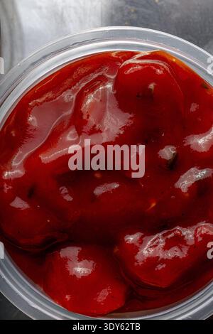 Consistenza della salsa di pomodoro rosso in un contenitore da vicino come arte Foto Stock