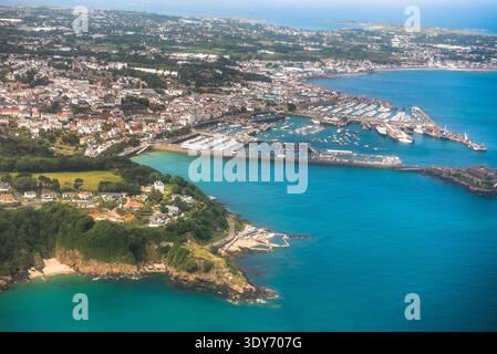 La vista aerea mostra il porto di San Pietro con porto, barche ed edifici sull'isola di Guernsey durante le ore diurne Foto Stock