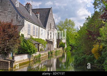 Riva del fiume Indre con edifici e vegetazione a Loches, in Francia, durante una giornata di sole Foto Stock