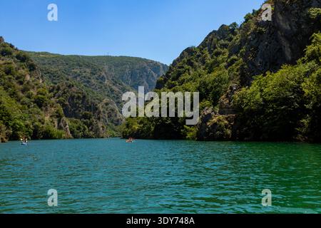 Esplora le limpide acque turchesi del canyon di Matka, circondato da ripide scogliere e alberi verdi a Skopje, in Macedonia, durante una giornata di sole Foto Stock