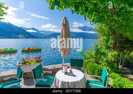 Il sole splende sul lago di Zell mentre i visitatori si rilassano sul lungomare di Zell am SEE, Salisburgo, Austria, durante una giornata luminosa Foto Stock