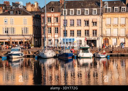 Case sul lungomare e barche al porto Vieux Bassin di Honfleur durante il giorno con gente che si gode i dintorni Foto Stock