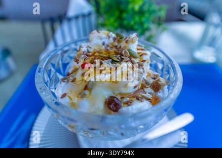 Yogurt greco tradizionale con miele e semi servito a Heraklion, Creta, Grecia durante un pasto Foto Stock
