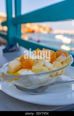 Tradizionale Macedonia greca di frutta allo yogurt servita in una località sul mare di Creta durante la stagione calda Foto Stock