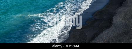 Vista aerea astratta panoramica della spiaggia di sabbia nera di Reynisfjara, banner di viaggio in Islanda Foto Stock