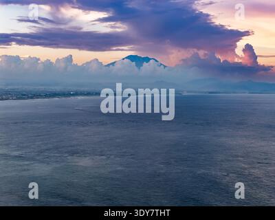Vista del vulcano del Monte Agung che si innalza sopra le nuvole al tramonto a Bali, Indonesia Foto Stock