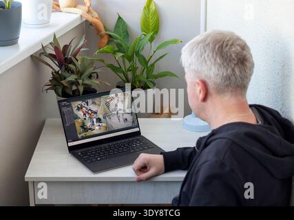 L'uomo controlla le riprese delle telecamere a circuito chiuso sul suo computer portatile Foto Stock