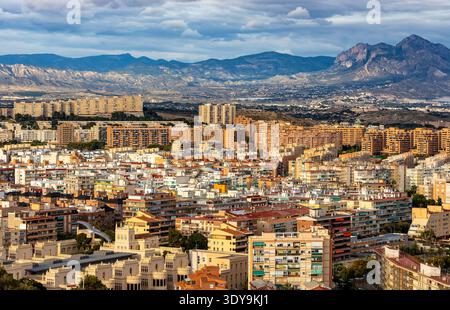 Alicante, Spagna - 20 gennaio 2026: Paesaggio urbano panoramico di Alicante con i quartieri urbani centrali e settentrionali e la catena montuosa della Serra de Mariola Foto Stock