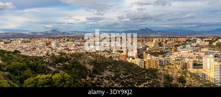 Alicante, Spagna - 20 gennaio 2026: Paesaggio urbano panoramico di Alicante con i quartieri urbani centrali e settentrionali e la catena montuosa della Serra de Mariola Foto Stock