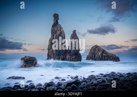 Vista del tramonto da Miradouro dos Ilheus da Ribeira da Janela con spettacolari formazioni rocciose che si innalzano dall'Oceano Atlantico a Madeira. Foto Stock