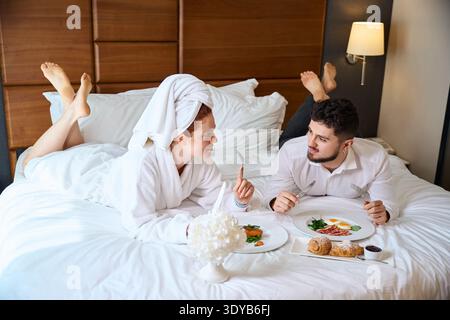 Coppia che gusta la colazione a letto in un'atmosfera intima Foto Stock