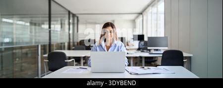 Donna professionale felice di mezza età che utilizza un notebook in ufficio. Foto Stock