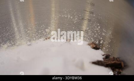 Pezzi di cioccolato e farina nel recipiente per la preparazione dei biscotti Foto Stock