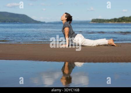Donna che pratica tai chi chuan e yoga sulla spiaggia. Capacità di gestione cinese QIS energia. attività individuali all'aperto. Distanziamento sociale || modello rilasciato Foto Stock