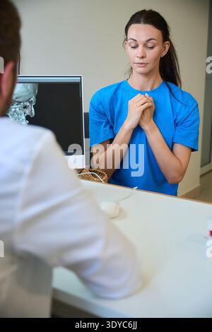 Donna preoccupata durante la visita medica in ufficio Foto Stock
