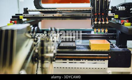 Braccio robotizzato che esegue operazioni di prelievo e posizionamento nella produzione di componenti elettronici Foto Stock