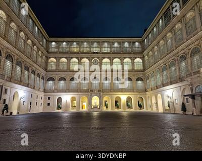 Una piazza vuota all'interno della città del Vaticano è illuminata di notte dalle luci. Foto Stock