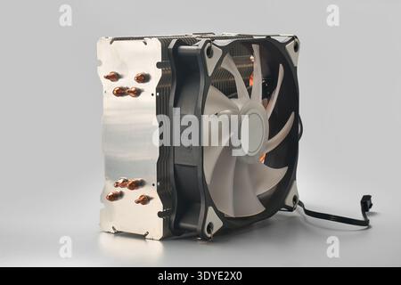 radiatore cpu tower computer sfondo grigio isolato, dissipatore di calore in metallo argento con tubi di calore in rame e ventola di raffreddamento in plastica bianca e nera, vista laterale Foto Stock
