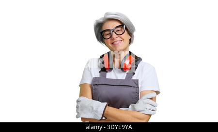 Lavoratrice matura che sorride indossando l'attrezzatura di protezione di sicurezza Foto Stock